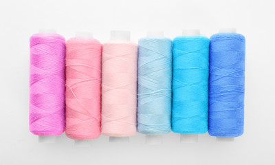 Many colorful threads on white background, top view