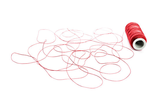 Spool of red thread on white background