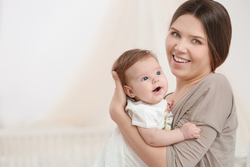 Young mother with her cute little baby at home