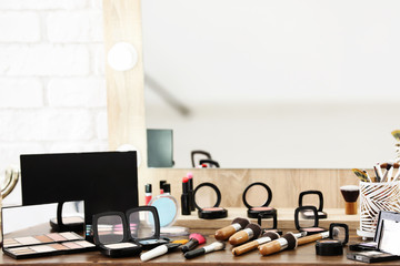 Decorative cosmetics and tools of professional makeup artist on dressing table