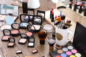 Decorative cosmetics and tools of professional makeup artist on dressing table
