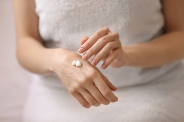 Young woman applying hand cream, closeup