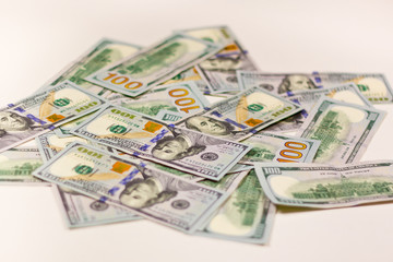 100 dollar bills scattered on a white background