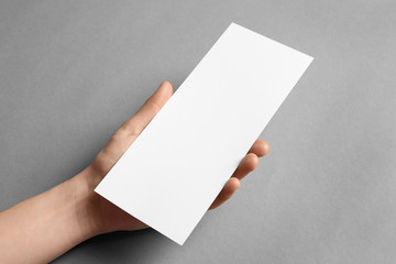 Woman holding blank card on grey background. Mock up for design