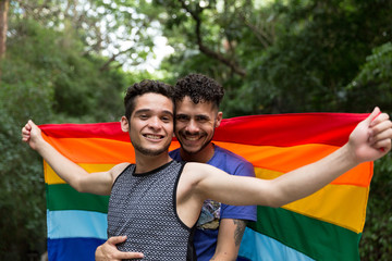 Gay Couple Celebrating with Rainbow Flag in the Park