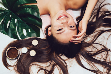 happy smiling girl with long hair enjoying and relaxing in spa