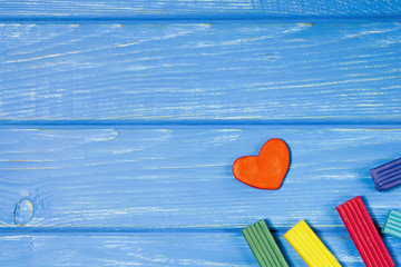 Heart made of plasticine on a wooden background