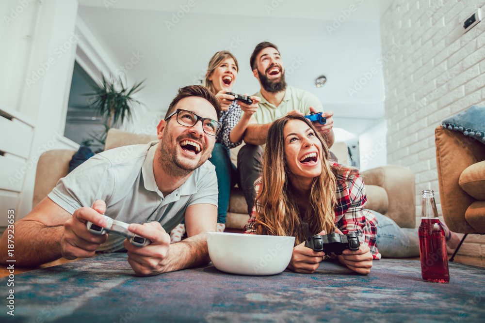 Wall mural group of friends play video games together.