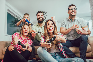 Group of friends play video games together.