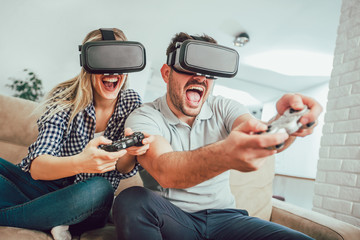 Happy friends playing video games with virtual reality glasses - Young people having fun with new...