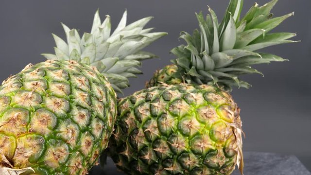 Rotating pineapple fruits isolated on a black background (loopable)