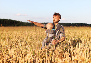 Naklejka na ściany i meble father shows his son a field of barley