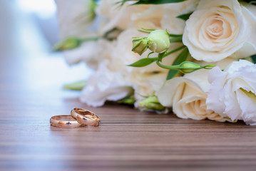 Gold wedding rings and bridal bouquet