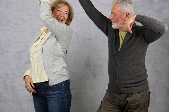 Happy stylish elderly couple dancing and laughing