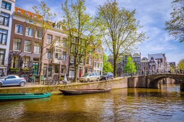 Traditional old buildings and and boats in Amsterdam, Netherlands. Canals of Amsterdam.
