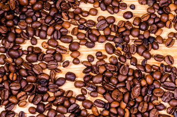 Pile of the roasted coffee beans on wooden table. Top view