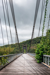 Suspension bridge of East River near Saint-Rose on a cloudy day, La Reunion in autumn