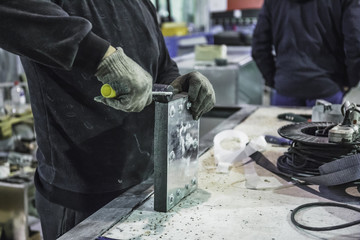 Close up of worker with tools equipment on factory manufacturing of modern metalworking production of industrial steel ventilation air systems