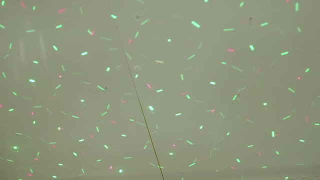 Light show projected on the ground: small red and green lights crossing.