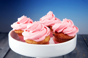 Tasty cupcakes on wooden background. Birthday cupcake in pink color