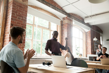 African american team leader performing funny victory dance celebrating achievement in co-working office, black businessman dancing excited by success or win, colleagues supporting clapping hands