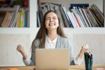 Excited female student feels euphoric celebrating online win success achievement result, young...