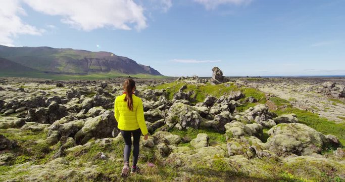 Woman traveler on Iceland walking in nature in amazing landscape on Iceland. Tourists on Iceland road trip visiting and sightseeing. RED EPIC SLOW MOTION.