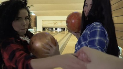 Two cute women invites cameraman to play bowling together with them