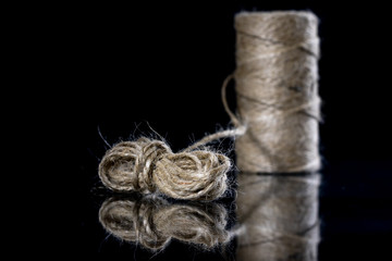 Jute string rolled into a ball. A string on a glass mirror table.