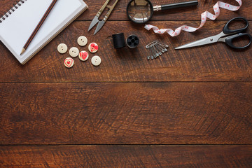 Top view aerial image fashion designer background concept.Flat lay sewing accessory or tailor tool work shop on modern rustic brown wooden at home office desk studio.Space for creative design mock up.