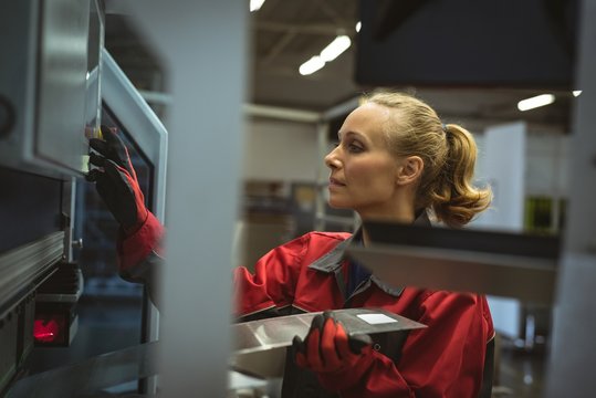 Female worker checking a machine