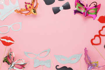 Table top view aerial image of beautiful carnival party mask or photo booth props background.Flat lay many objects on modern rustic pink paper at office desk studio.space for creative design mock up.
