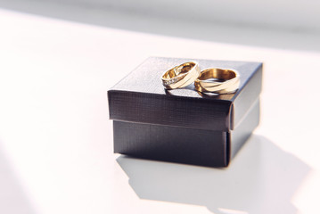Gold wedding rings with inscription inside on the craft box.
