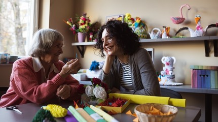 Senior woman interacting with caretaker at nursing home