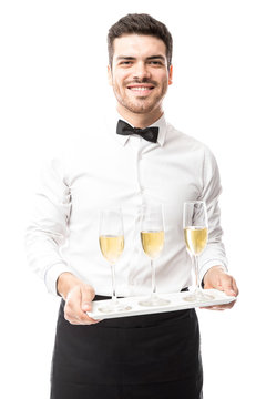 Attractive waiter serving champagne