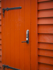Puerta con control de accesos de color naranja. Noruega , verano 2017