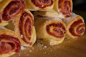 Delicious sweet rolls with red jam stacked on wood desk