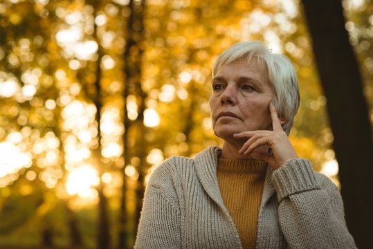Thoughtful senior woman in autumn park