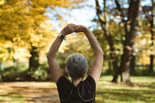 Rear view of senior woman practicing yoga in a park