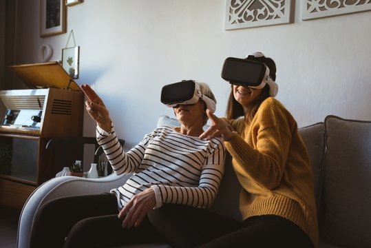 Senior woman and daughter wearing a virtual reality headset
