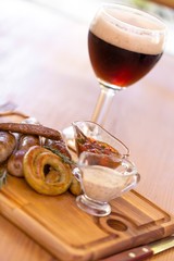 Meat on Cutting Board with Sauces and Drink