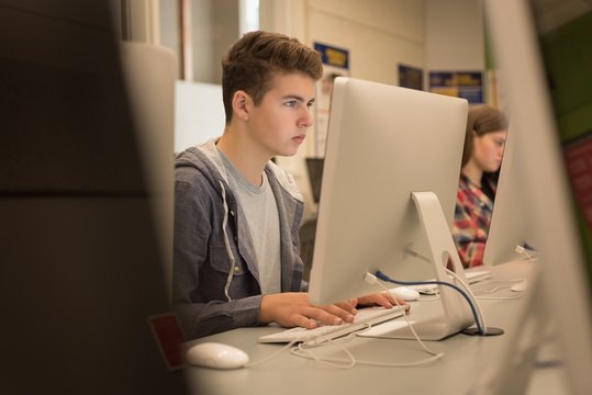 Teenage boy studying in computer classroom