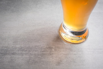 Bottom of glass of beer on a stone background.