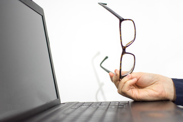 Girl holding glasses on the laptop