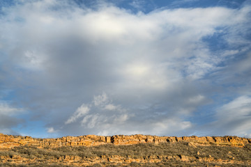 clouds over sandstone cliff