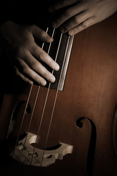 Double bass player Hands playing contrabass strings