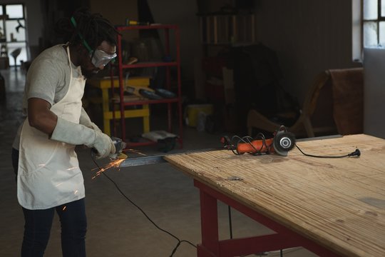 Carpenter cutting metal with electric saw