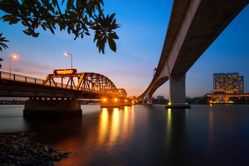 Light of Bridge and twilight sky with smooth motion river reflection in Bangkok