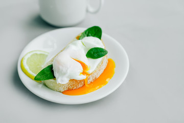 Breakfast eggs Benedict with spinach and lemon tea