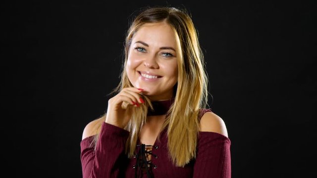 Pretty blond woman smiling and acting playful.